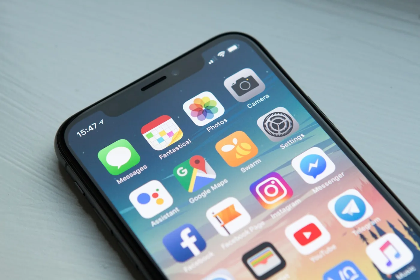 Elinde akıllı telefon tutan bir kişi, ekranda uygulama görünüyor